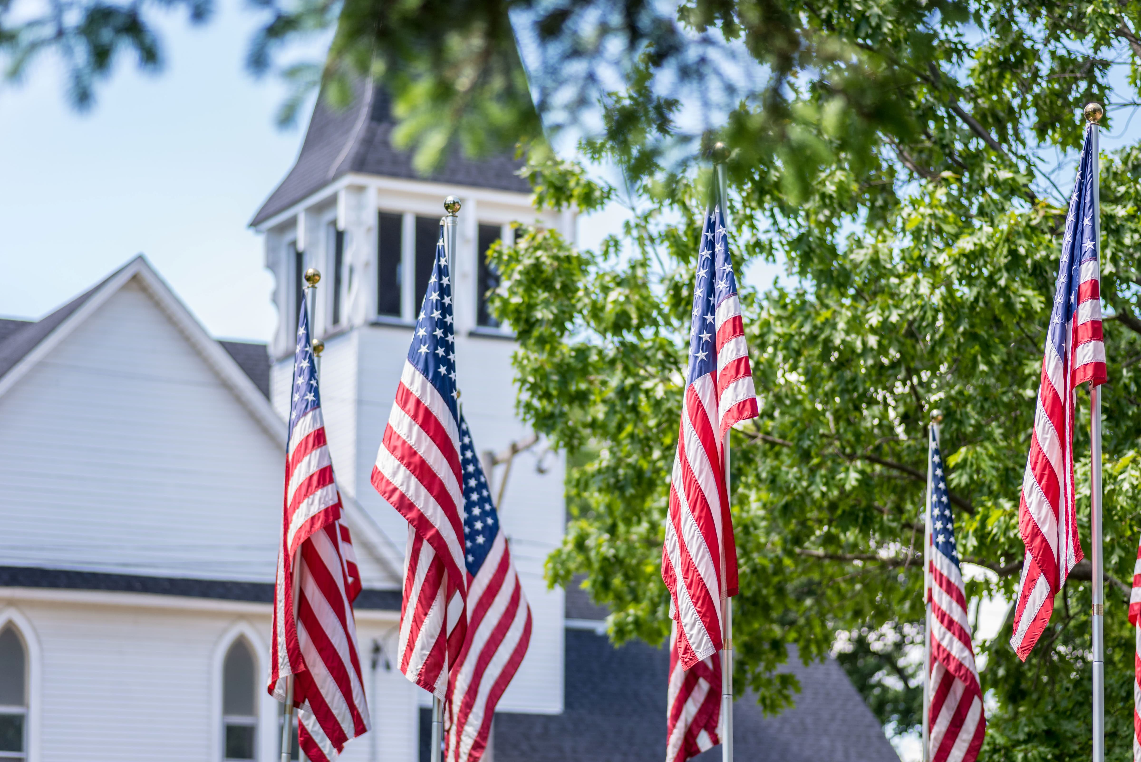 Beautiful tradition church in smalltown USA with American flags lining the lawn